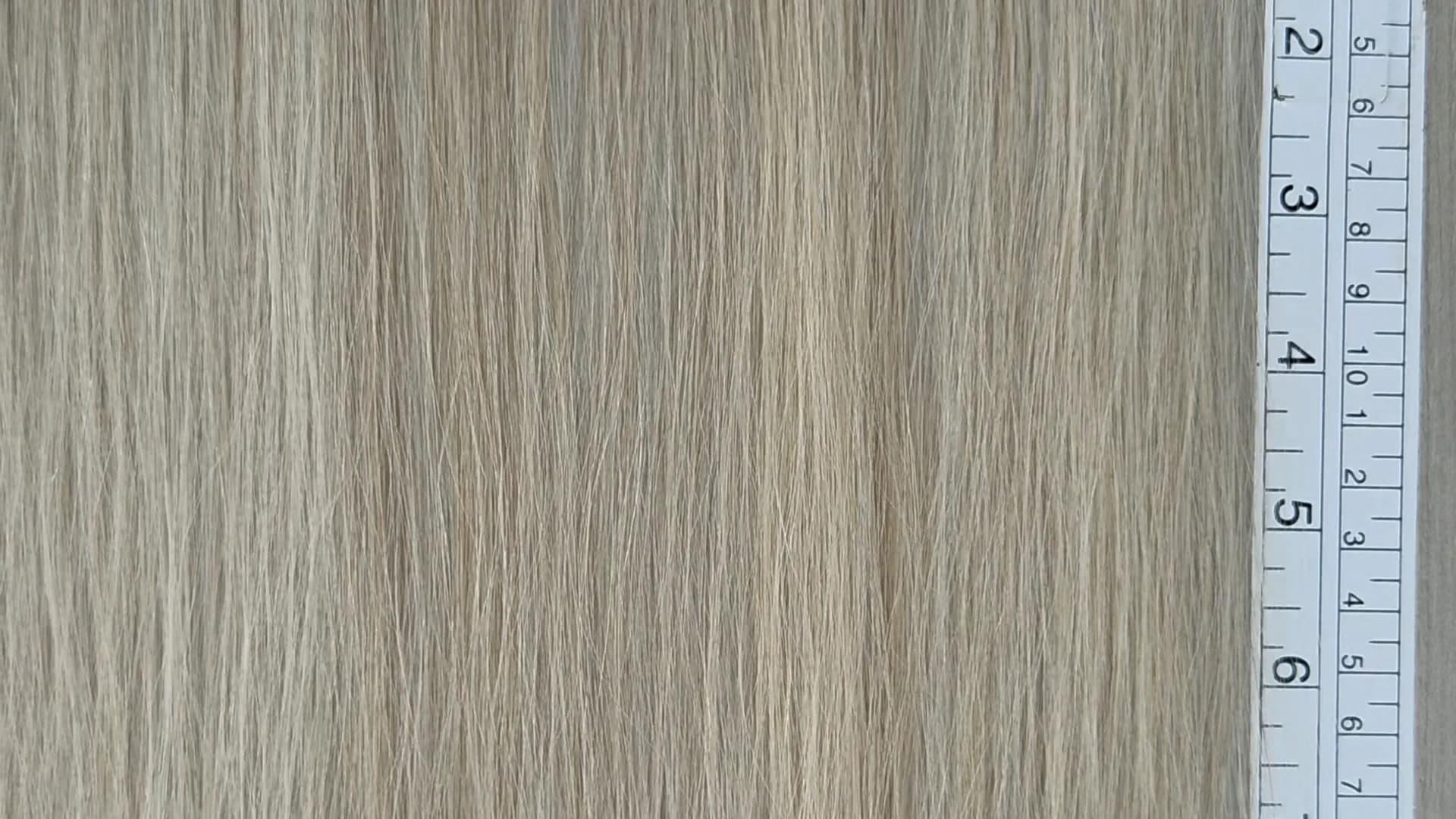 Platinum hair combed flat on the lab table beside a measuring ruler